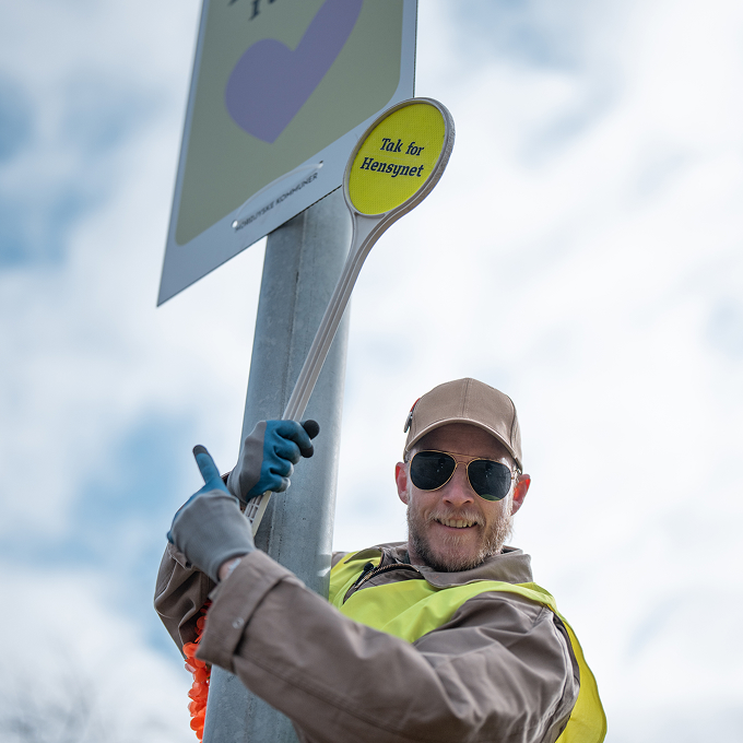 Søre Vige i en lygtepæl med 'Vis hensyn' skilt i håden.